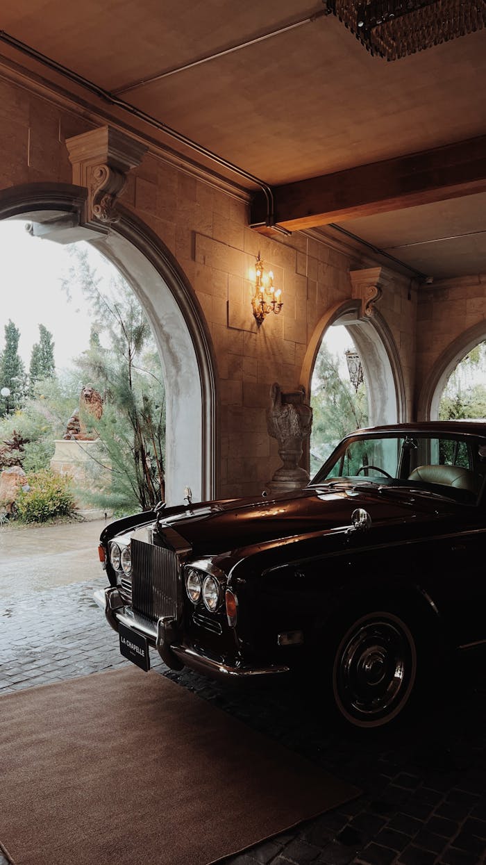 Crafting Captivating Headlines: Your awesome post title goes here Classic luxury car parked indoors with elegant stone arches and chandeliers.